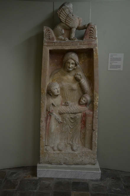 Idalion, Funerary stele of a young mother, holding a fruit in her left hand, with child and baby, crowned with a sphinx between two acroteria