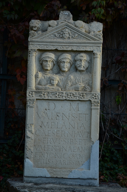 Tombstone with three adults and a child with Roman inscription