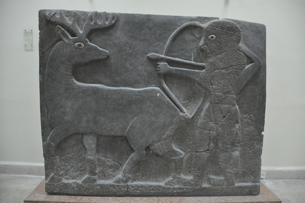 Tell Halaf, West palace entrance, orthostat of a winged sun disk, supported by two bull-man and a kneeling man with three lines of cuneiform inscription