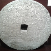 Wiederverwendung eines römischen Inschriftblocks als Mühlstein