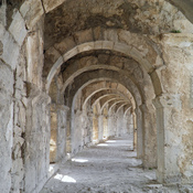 Vaulted arched walkway running around the top of semi-circular cavea of the Roman theatre