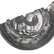 Half of a silver platter showing the head of Hercules.